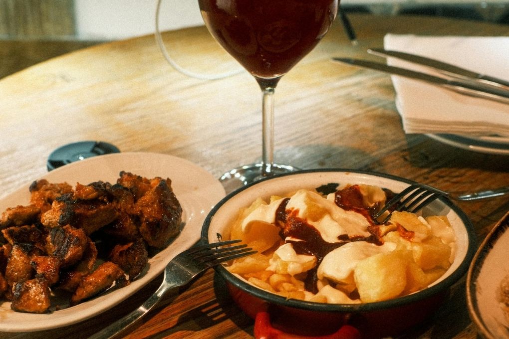 Travellers enjoying a Barcelona tapas and wine tour with local dishes, vermut and Catalan food.